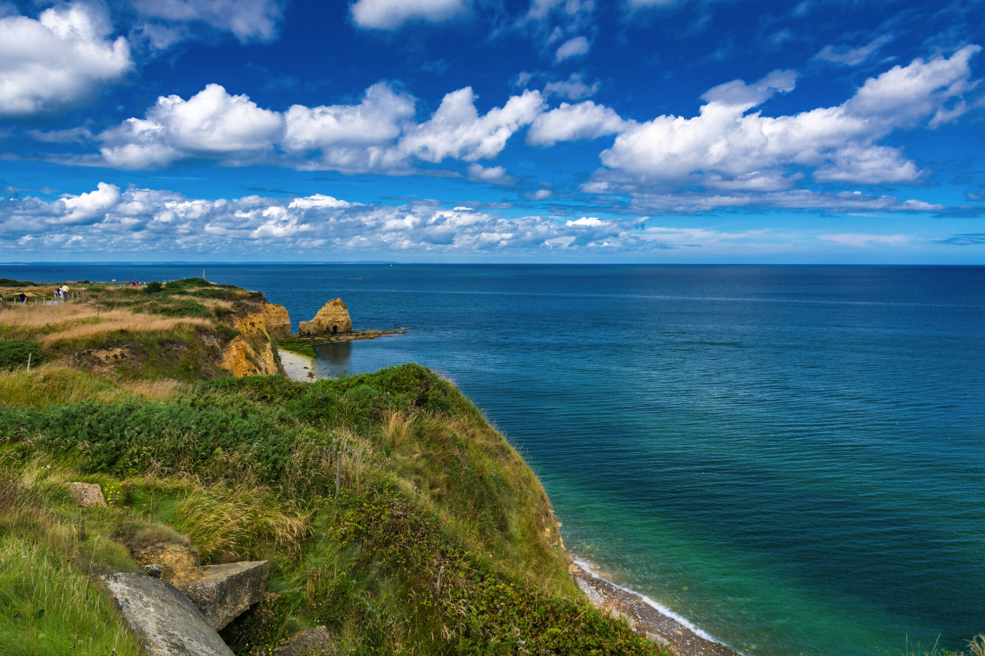 Atemberaubender Blick auf die Küste der Normandie: goldene Felsen, türkisblaues Meer und weite Horizonte laden zu einer unvergesslichen Busreise nach Frankreich ein. Entdecken Sie geschichtsträchtige Orte, malerische Landschaften und den Zauber des Atlantiks.