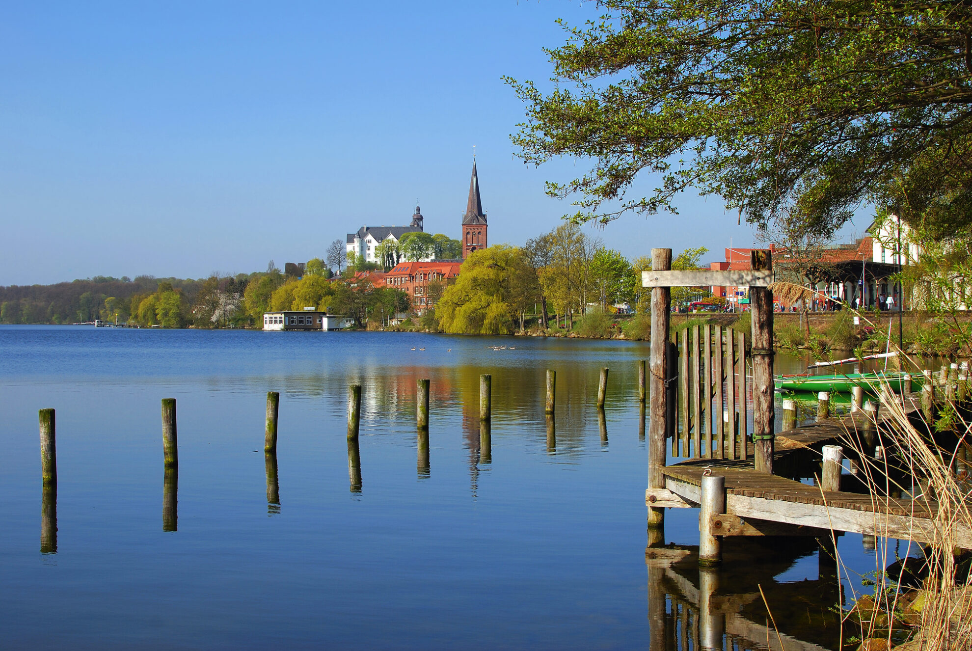 Blick auf den Schlosssee in Plön mit historischem Schloss und Kirche in der Holsteinischen Schweiz