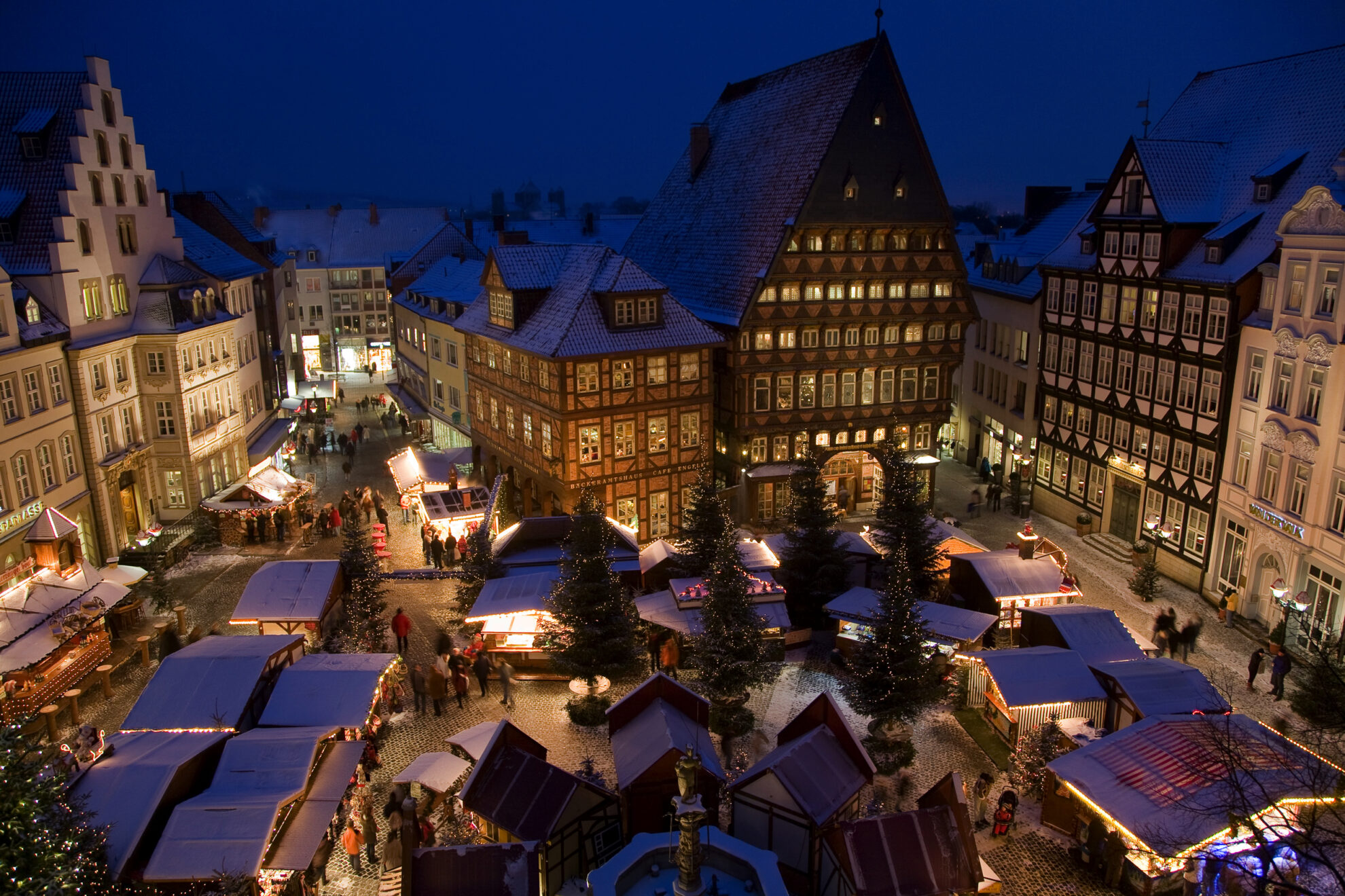 Romantischer Weihnachtsmarkt in historischer Fachwerkstadt – festliche Adventsstimmung mit Lichtern, Buden und verschneitem Marktplatz.
