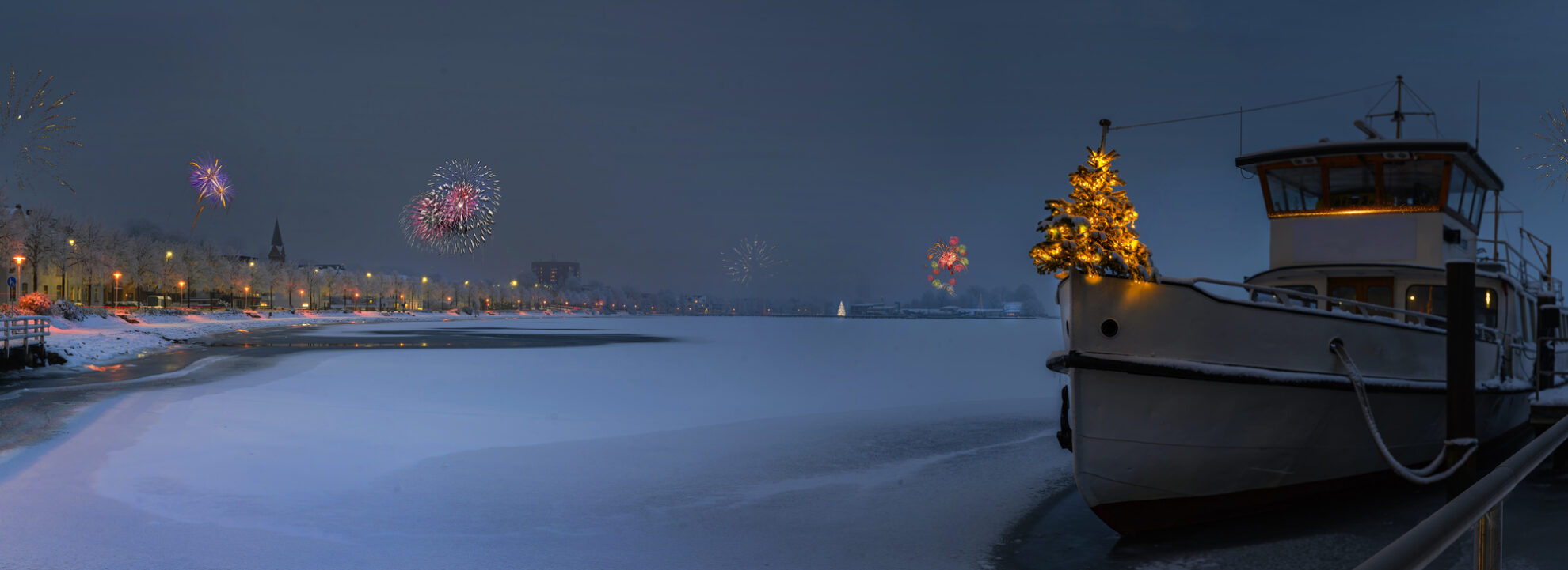 Winterliche Hafenstimmung mit beleuchtetem Schiff, Feuerwerk und festlichem Weihnachtsbaum