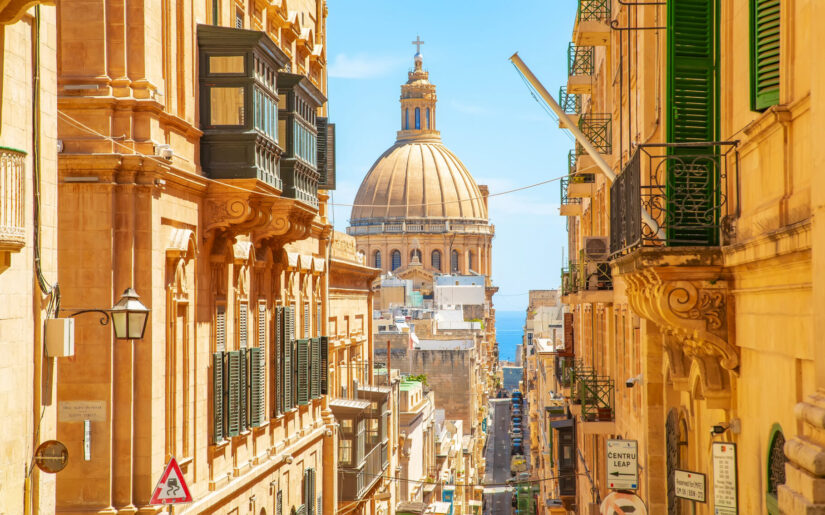 Blick auf die Kuppel der Basilika Our Lady of Mount Carmel in Valletta, Malta. Die historischen Sandstein-Gassen der Altstadt und der Blick auf das Mittelmeer machen die Hauptstadt zu einem einzigartigen Reiseziel im Mittelmeerraum.