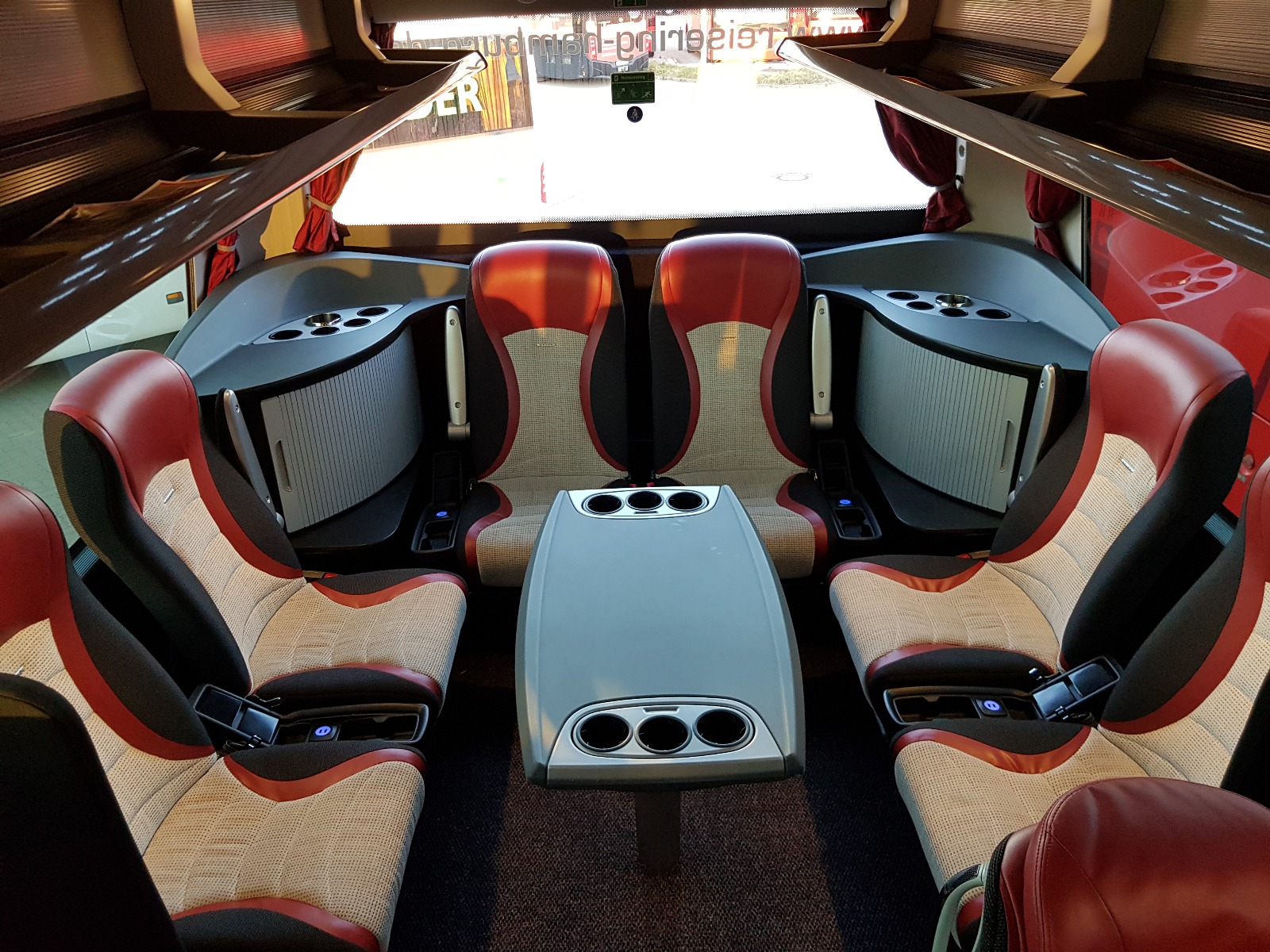 Gemütliche Sitzgruppe im Reisebus des Reisering Hamburg – stilvolles Ambiente, bequeme Ledersitze und viel Platz für Gespräche und Gemeinschaft auf komfortablen Busreisen ab Hamburg.