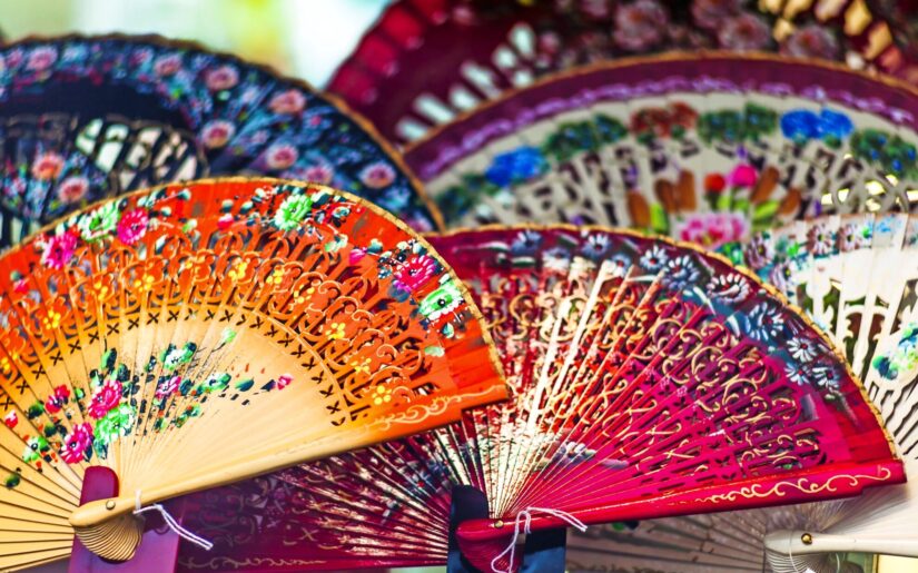Bunte Handfächer mit filigranen Blumenmustern – traditionelles Kunsthandwerk, das Eleganz und Kultur verbindet. Beliebtes Souvenir auf Reisen nach Spanien.