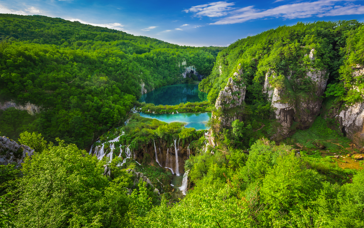 Wasserfälle und Seen in einer grünen Waldlandschaft.