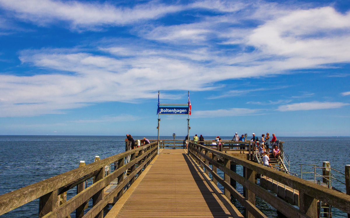 Holzsteg in die Ostsee mit Menschen und blauem Himmel in Boltenhagen.
