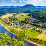 Landschaft mit Fluss, Feldern und Dorf in einer hügeligen Region. von der Basteibrückt, Blick auf Rathen