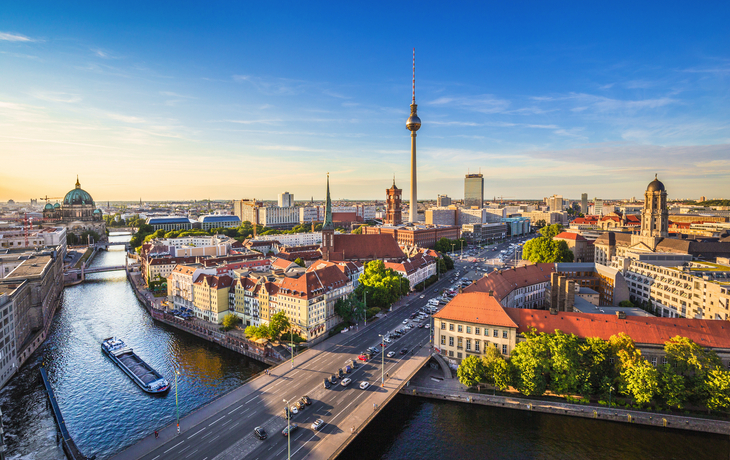 Berliner Skyline mit Fernsehturm und der Spree bei Sonnenuntergang.