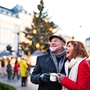 Älteres Paar auf einem Weihnachtsmarkt vor einem geschmückten Baum.