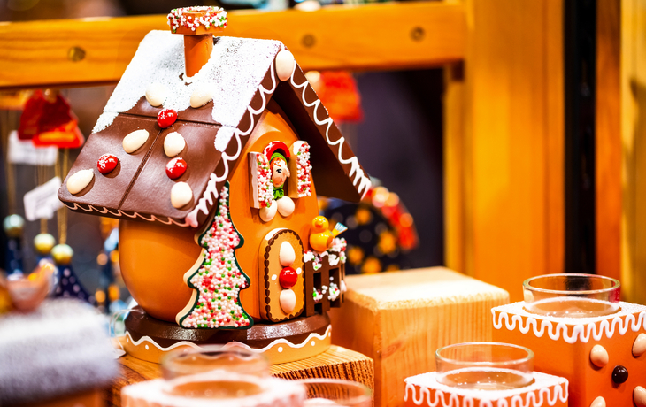 Lebkuchenhaus mit bunten Dekorationen auf einem Weihnachtsmarkt.