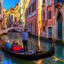 Gondel in Venedig auf einem Kanal vor bunten Häusern.