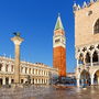Piazza San Marco in Venedig mit Markusturm und Dogenpalast bei sonnigem Wetter.