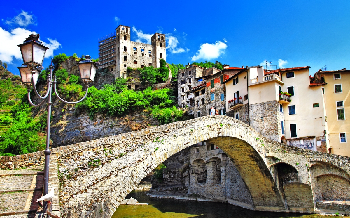 Dolceaqua Historische Steinbrücke in mittelalterlicher Stadt mit Burg und blauen Himmel.