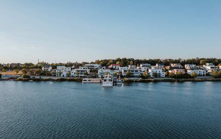 Wassertanksiedlung am Seeufer unter blauem Himmel