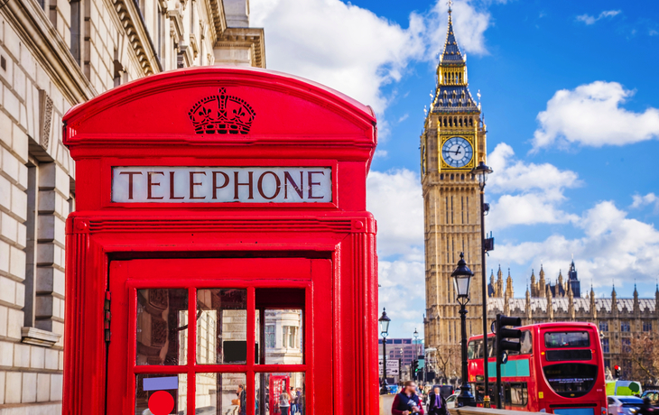 Rote Telefonzelle und Big Ben in London bei blauem Himmel.