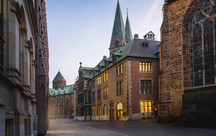 Historische Backsteingebäude mit Türmen bei Sonnenuntergang.