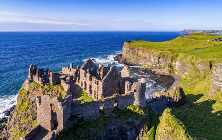 Luftaufnahme von Schlossruine an der irischen Küste mit Meer und Klippen im Hintergrund