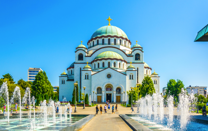 Orthodoxe Kathedrale mit grünen Kuppeln und Springbrunnen im Vordergrund bei klarem Himmel.