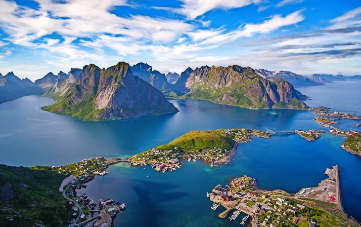 Luftaufnahme einer malerischen Küstenlandschaft mit Bergen und Dörfern.