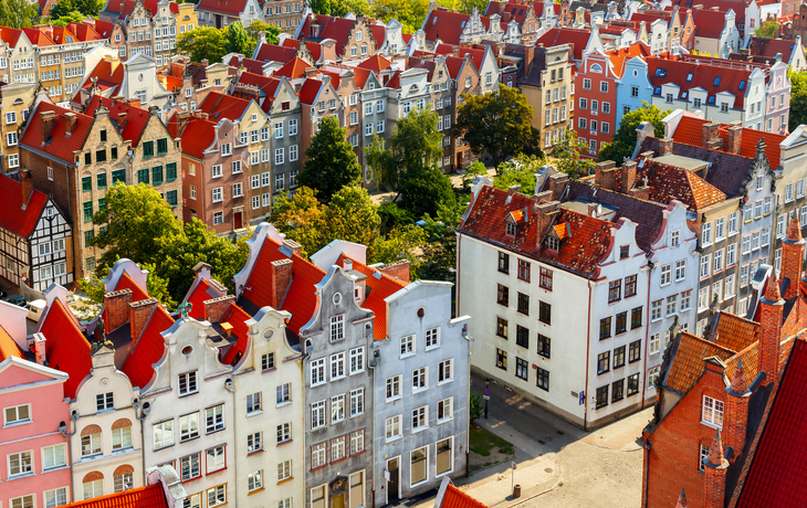 Bunte historische Gebäude in einer Altstadt mit roten Dächern aus der Vogelperspektive.
