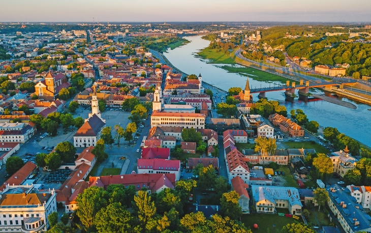 Luftbild einer Stadt mit Fluss und Brücken im Sonnenuntergang.