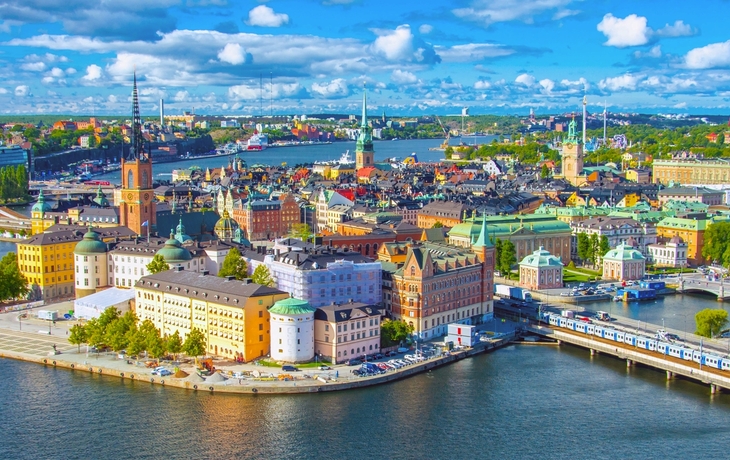 Panorama von Stockholm mit Gebäuden und Fluss unter blauem Himmel.