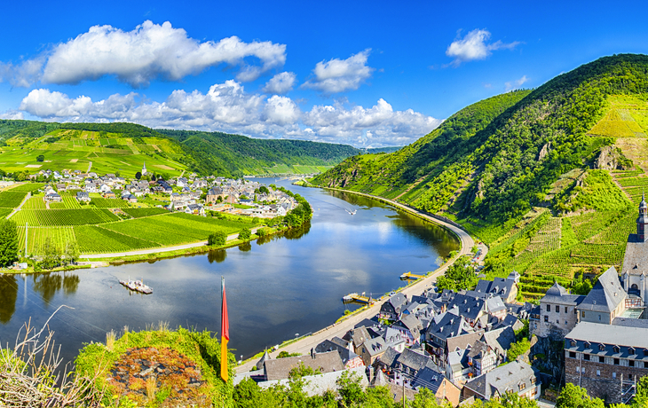 Panorama einer Flusslandschaft mit Weinbergen und einem Dorf im Tal.