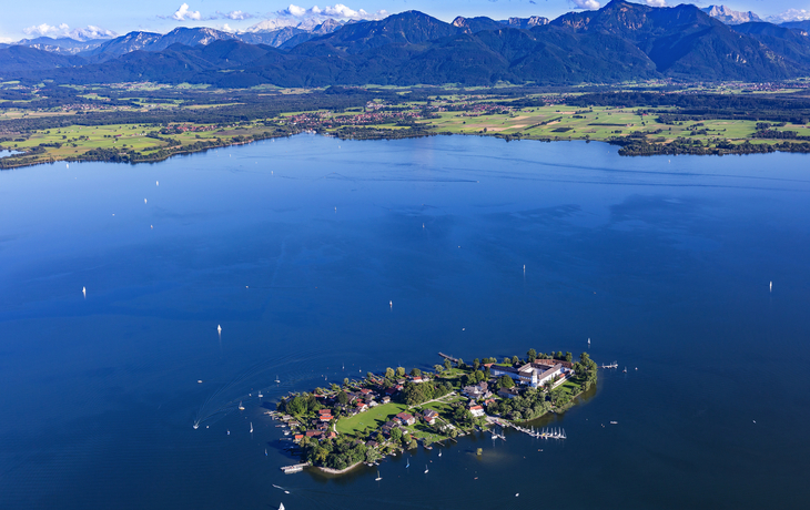 Landschaft mit See, Insel und Bergen im Hintergrund.