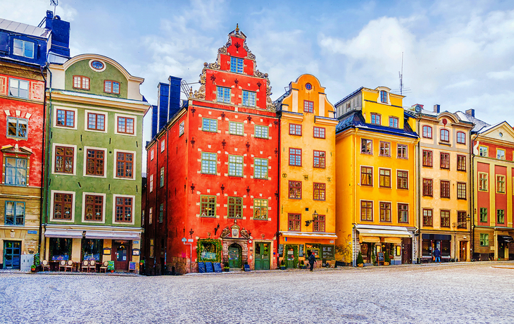 Stockholm im Winter mit bunten Altbauten, verschneiter Platz, weihnachtliche Atmosphäre.