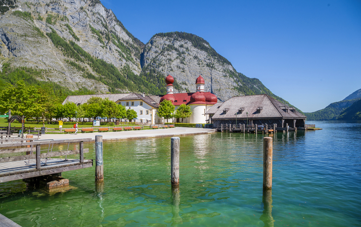 Blick auf St. Bartholomä am Königssee mit Bergen im Hintergrund.