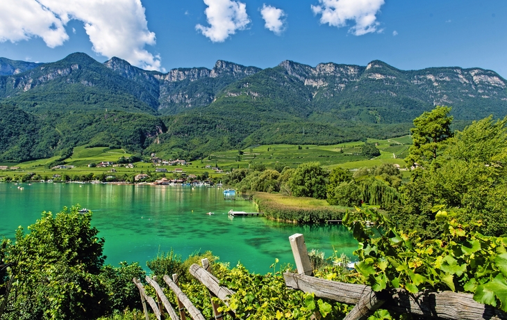 Blick auf den Kalterer See mit Berglandschaft im Hintergrund.