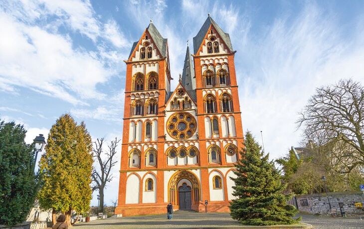 Zweiturmige Kathedrale mit orange-gelben Fassadendetails unter blauem Himmel.