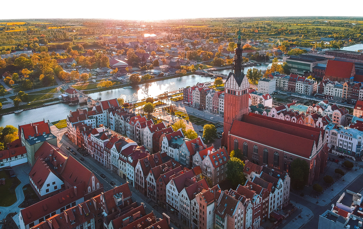 Stadtansicht mit Kirche und Fluss bei Sonnenuntergang aus der Vogelperspektive