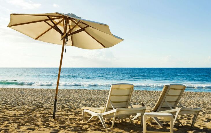 Strand mit Liegestühlen und Sonnenschirm, Blick aufs Meer