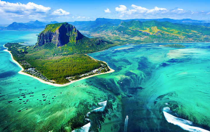 Luftaufnahme einer tropischen Insel mit Strand und türkisfarbenem Meer.