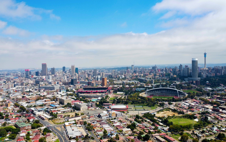 Stadtansicht aus der Luft mit Stadion und Wolken am Himmel.
