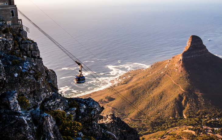 Seilbahn in gebirgiger Landschaft mit Blick auf das Meer.