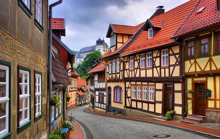 Malerische Fachwerkhäuser an einer kurvigen Straße in einer historischen Altstadt.