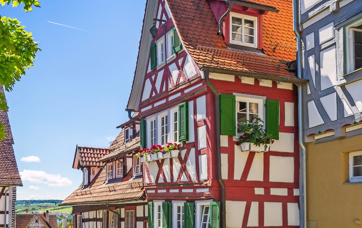 Fachwerkhäuser in einer malerischen Altstadt mit blauem Himmel.