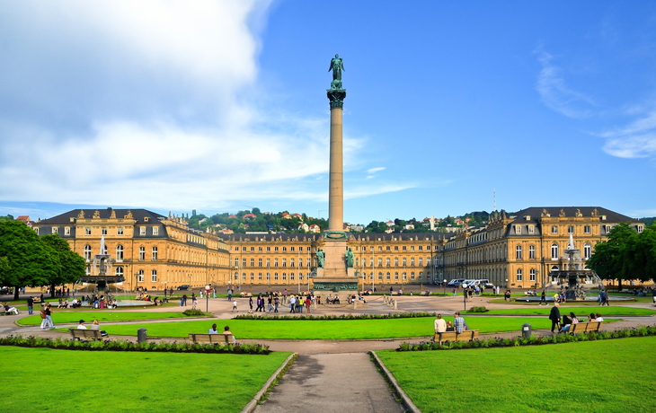 Schlossplatz in Stuttgart mit Jubiläumssäule und Menschen im Grünen.