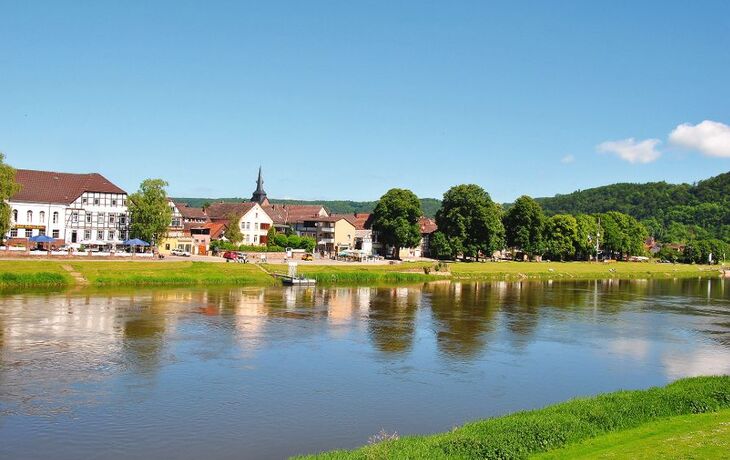 Kleinstadt an der Weser mit Fachwerkhäusern und Uferpromenade im Weserbergland.