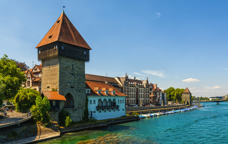 Mittelalterlicher Wachturm am Fluss in einer europäischen Stadt bei sonnigem Wetter.