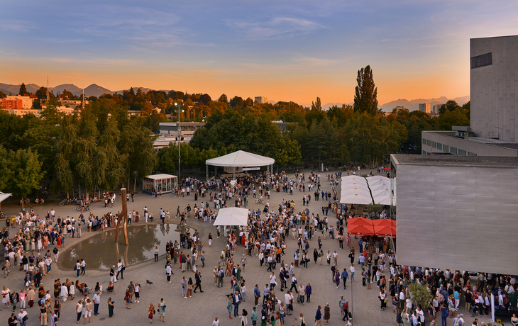 Menschenmenge auf einem Platz bei Sonnenuntergang, Bregenzer Festspiele.