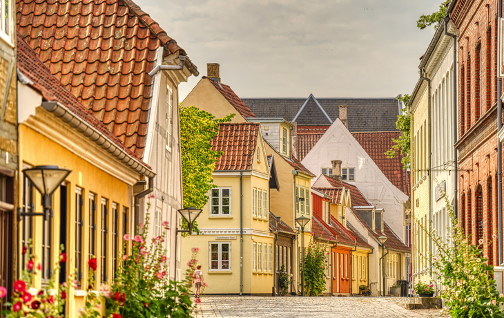 Malerische Straße mit bunten, historischen Gebäuden und Kopfsteinpflaster.