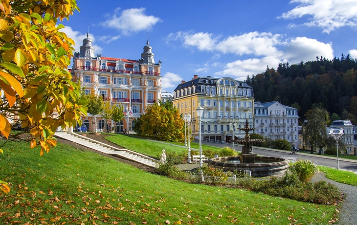 Historische Gebäude mit Garten und Brunnen im Vordergrund