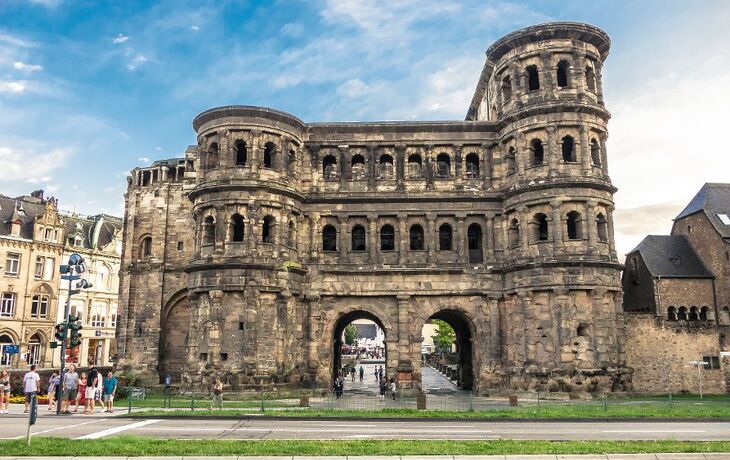 Historisches römisches Stadttor aus Stein bei blauem Himmel.