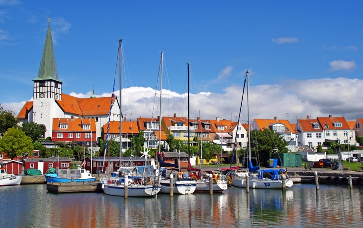 Hafen mit Segelbooten und bunten Häusern im Hintergrund