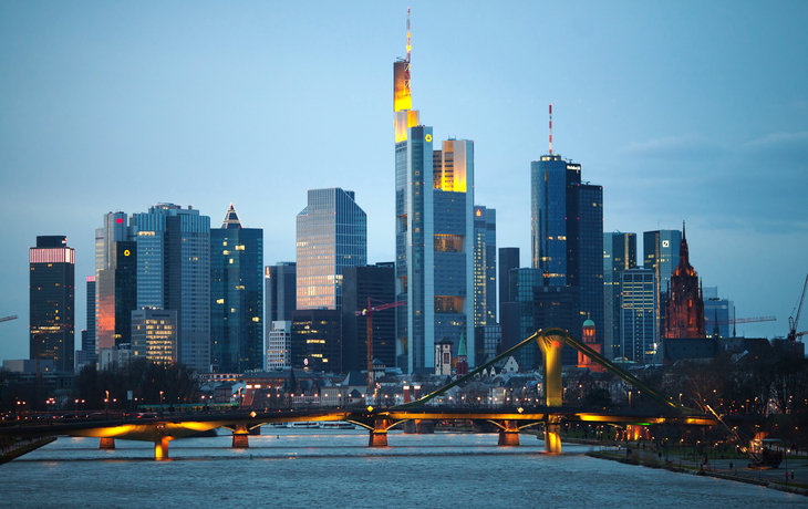 Frankfurter Skyline mit Wolkenkratzern und Eisernem Steg in der Abenddämmerung